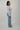 Women's blue tailored double-breasted blazer with silver button details styled with a white tank top and light wash straight-leg jeans for a chic business casual outfit.