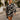 Woman wearing a long sleeve noir palm skirt set walking on through resort.