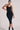 Black ribbed midi dress for women featuring a racerback silhouette and white stripe back detail, styled for resort wear and vacation outfits by YAHKARA
