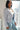 Woman wearing blue cropped blazer with a white top and denim jeans for a casual sophisticated yet elegant look.