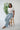 Woman sitting on a stool showing how comfortable the breathable and sustainable Tincel rawstring pant is.