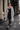 Woman wearing the YAHKARA Soho Hooded Cardigan in gray with a black scoop-neck top, black leggings, and sneakers while walking through SoHo NYC holding a coffee.