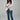 Woman wearing YAHKARA white double-breasted blazer with gold buttons styled with denim jeans for a luxury business casual look
