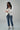 Woman wearing YAHKARA white double-breasted blazer with gold buttons styled with denim jeans for a luxury business casual look